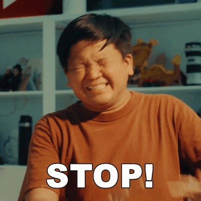 A Man In A Brown Shirt Is Making A Stop Sign With His Eyes Closed GIF