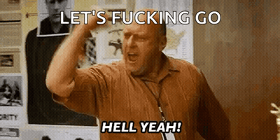 A Man In A Brown Shirt Is Screaming And Holding His Fist In The Air . GIF