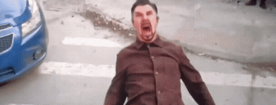 A Man In A Brown Shirt Is Screaming In Front Of A Blue Car On A City Street . GIF