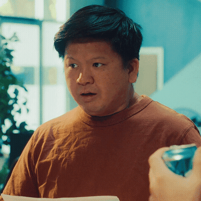 A Man In A Brown Shirt Looks Surprised While Holding A Can Of Soda GIF