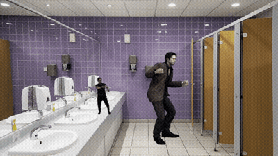 A Man In A Brown Suit Is Dancing In A Public Restroom GIF