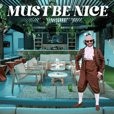 A Man In A Brown Suit Stands In Front Of A Restaurant With The Words Must Be Nice Above Him GIF