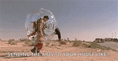A Man In A Bubble Is Walking Down The Street . GIF