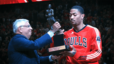 A Man In A Bulls Jersey Holds A Trophy In Front Of A Crowd GIF