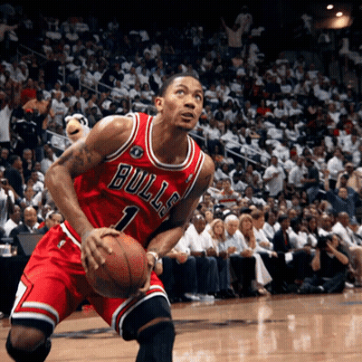 A Man In A Bulls Jersey Is Holding A Basketball In Front Of A Crowd GIF