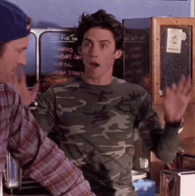 A Man In A Camo Shirt Is Standing In Front Of A Chalkboard That Says Key For Tom GIF