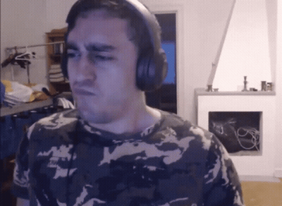 A Man In A Camo Shirt Is Wearing Headphones And Making A Face GIF