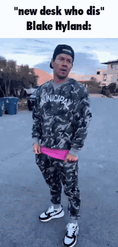 A Man In A Camouflage Shirt And Pants Is Standing On A Street . GIF