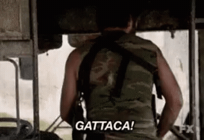 A Man In A Camouflage Vest Is Holding A Gun And Saying `` Gattaca '' . GIF