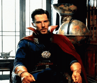 A Man In A Cape And Gloves Is Sitting In Front Of A Window . GIF