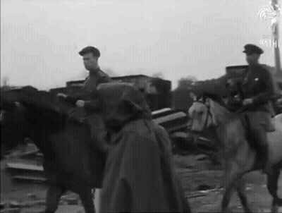 A Man In A Cape Is Riding A White Horse GIF