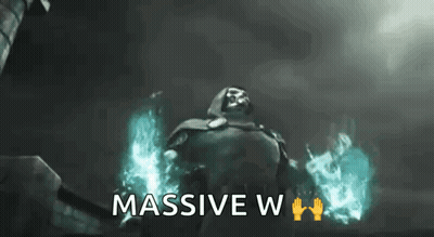 A Man In A Cape Is Standing In Front Of A Building With The Words `` Massive W '' Written Below Him . GIF