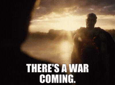 A Man In A Cape Is Standing In Front Of A Sunset With The Words There 'S A War Coming . GIF