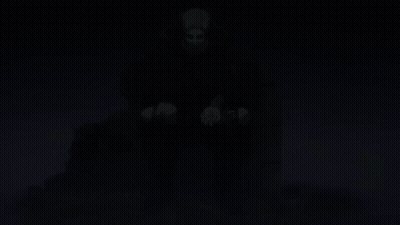 A Man In A Cape Sits On A Throne With His Hands In His Pockets GIF