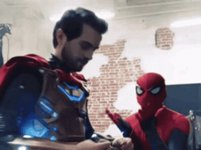 A Man In A Cape Stands Next To A Man In A Spider Man Costume GIF