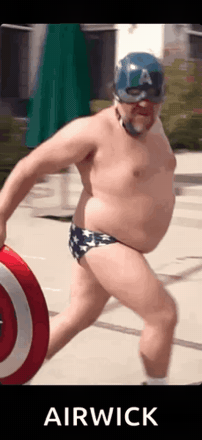 A Man In A Captain America Costume Is Holding A Shield GIF