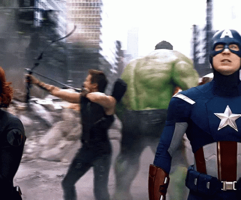 A Man In A Captain America Costume Is Standing In Front Of A Hulk GIF