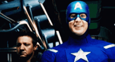 A Man In A Captain America Costume Stands Next To Another Man GIF