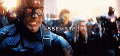 A Man In A Captain America Uniform Is Standing In Front Of A Crowd Of People And The Word Assemble Is Visible . GIF