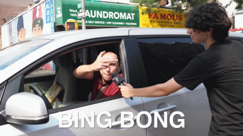 A Man In A Car Is Being Interviewed By Another Man In Front Of A Famous Rotisserie And Grill Sign GIF