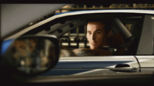 A Man In A Car With A Tattoo On His Arm GIF