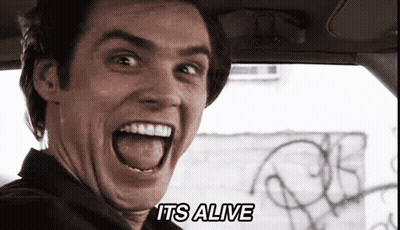 A Man In A Car With His Mouth Open And The Words It 'S Alive On The Bottom GIF