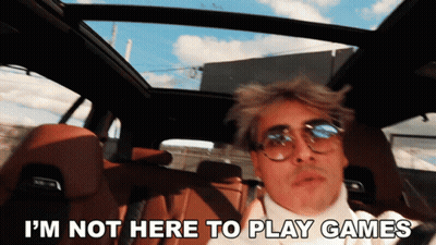 A Man In A Car With The Words " I 'M Not Here To Play Games " Below Him GIF