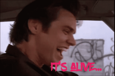A Man In A Car With The Words It 'S Alive In Pink GIF