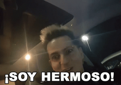 A Man In A Car With The Words Soy Hermoso Written Below Him GIF