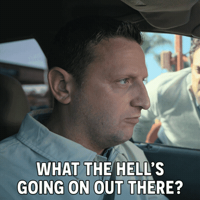 A Man In A Car With The Words What The Hell 'S Going On Out There Written Below Him GIF