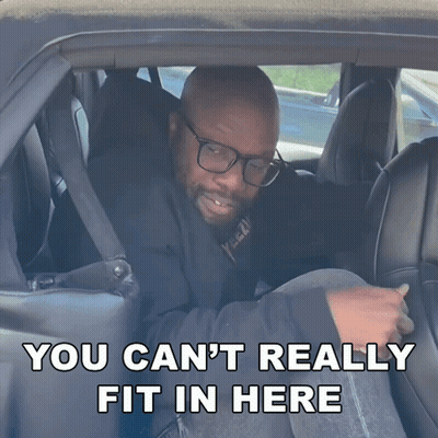 A Man In A Car With The Words " You Can T Really Fit In Here " GIF