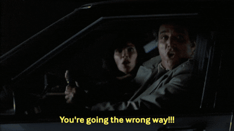 A Man In A Car With The Words You 'Re Going The Wrong Way On The Bottom GIF