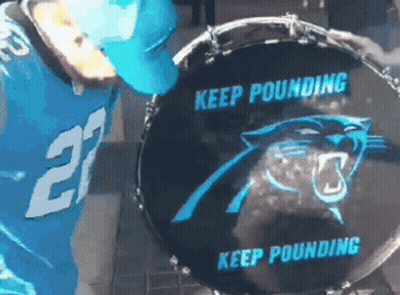 A Man In A Carolina Panthers Jersey Is Playing A Drum GIF