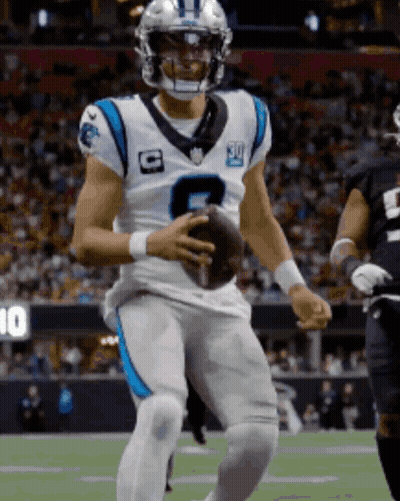 A Man In A Carolina Panthers Uniform Holds A Football GIF