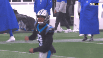 A Man In A Carolina Panthers Uniform Is Running On The Field GIF