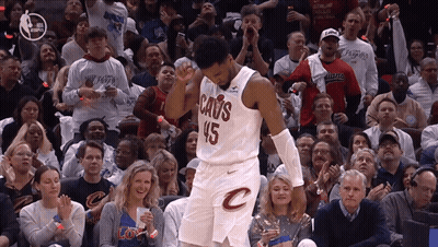 A Man In A Cavs Jersey Stands In Front Of A Crowd Of People GIF