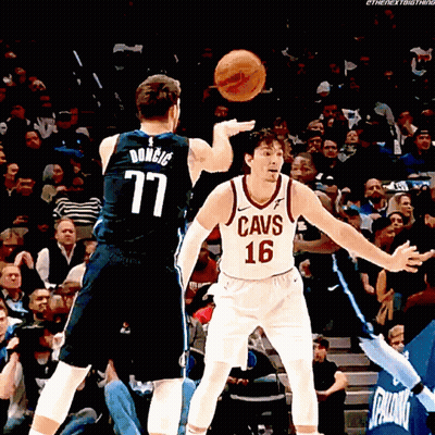 A Man In A Cavs Jersey Throws A Basketball At Another Man GIF