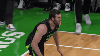 A Man In A Celtics Jersey Is Standing On A Basketball Court GIF