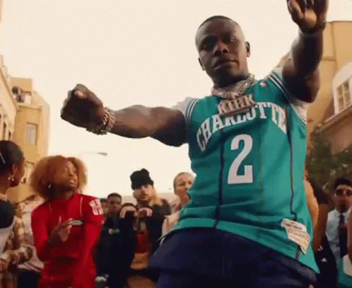 A Man In A Charlotte Jersey Is Dancing In Front Of A Crowd . GIF