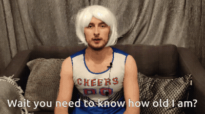 A Man In A Cheerleader Costume Is Sitting On A Couch GIF