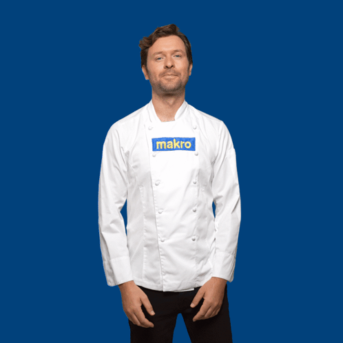 A Man In A Chef 'S Jacket Stands In Front Of A Blue Background With The Word Gracias Written In Yellow GIF