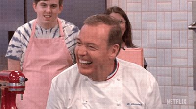 A Man In A Chef 'S Uniform Is Laughing In Front Of A Mixer And A Sign That Says Netflix GIF