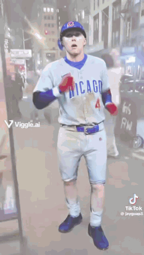 A Man In A Chicago Cubs Uniform Is Dancing On A Street . GIF