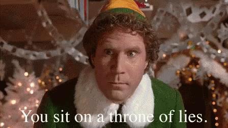 A Man In A Christmas Elf Costume Is Sitting On A Throne Of Lies In Front Of A Christmas Tree . GIF