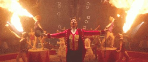 A Man In A Circus Costume Is Surrounded By Flames And Bubbles GIF