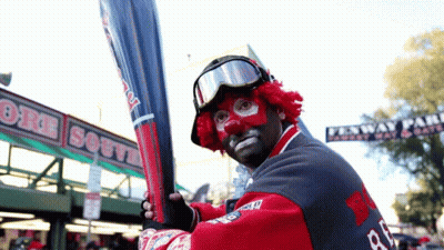 A Man In A Clown Costume Is Holding A Bat In Front Of A Sign That Says Boston South GIF