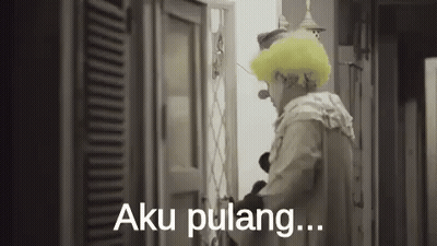A Man In A Clown Costume Is Standing In Front Of A Door And Saying Aku Pulang . GIF