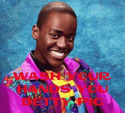 A Man In A Colorful Jacket Is Smiling With The Words " Wash Your Hands You Deity Pic " Behind Him GIF
