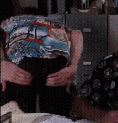 A Man In A Colorful Shirt Is Being Held By Another Man GIF