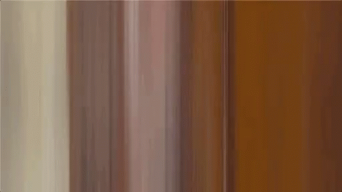 A Man In A Colorful Shirt Is Making A Funny Face . GIF